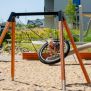 Single Swing (BNS 90cm) с дървена рамка и кръгла люлка с мрежа на детска площадка.